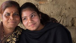 An Indian woman and her niece, a survivor of domestic violence, embrace