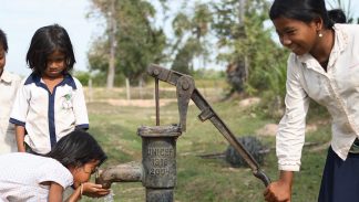 Woman and children in Cambodia celebrate their new water pump