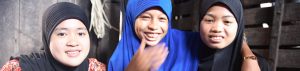 Three laughing Muslim girls in a Cambodian village