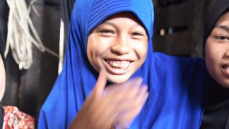 Three laughing Muslim girls in a Cambodian village