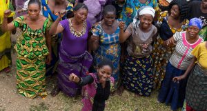 Amina leads the women in her community in a cheer.